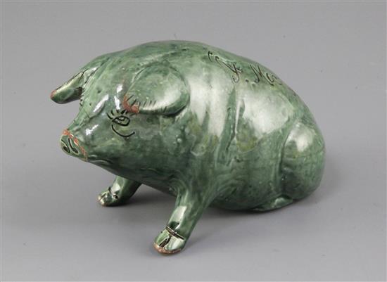 A Ewenny green glazed pottery model of a seated pig, length 16.5cm